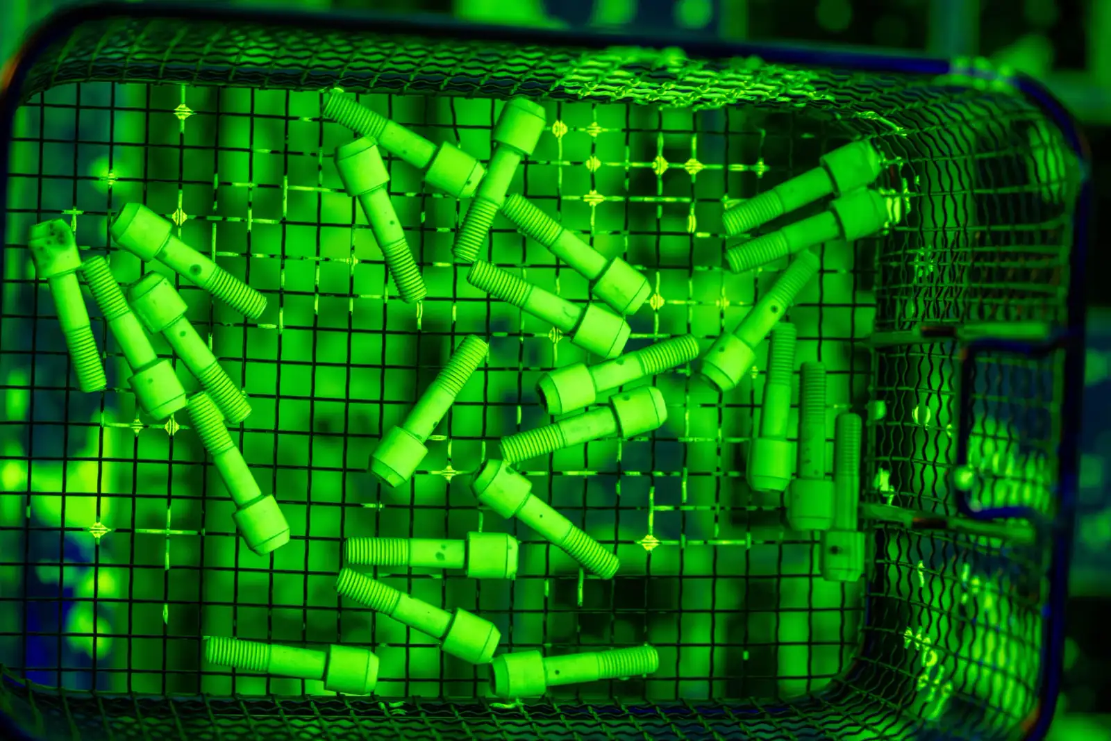 Bolts glowing under UV light during fluorescent penetrant inspection